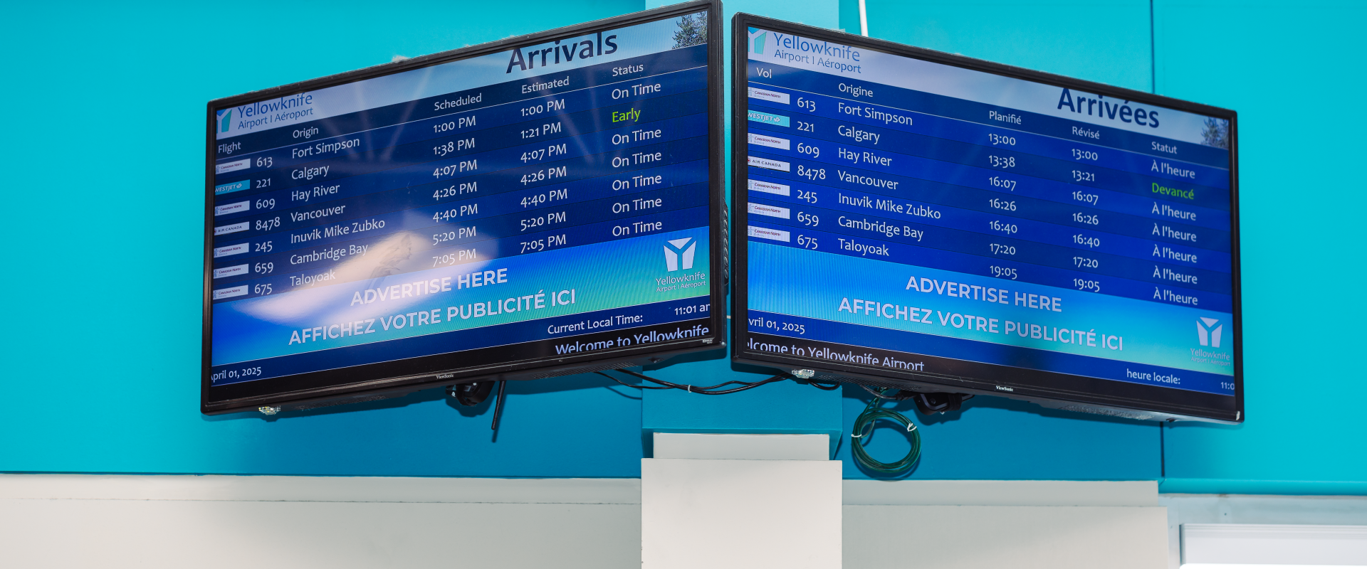 The image features two large TV screens displaying flight information
