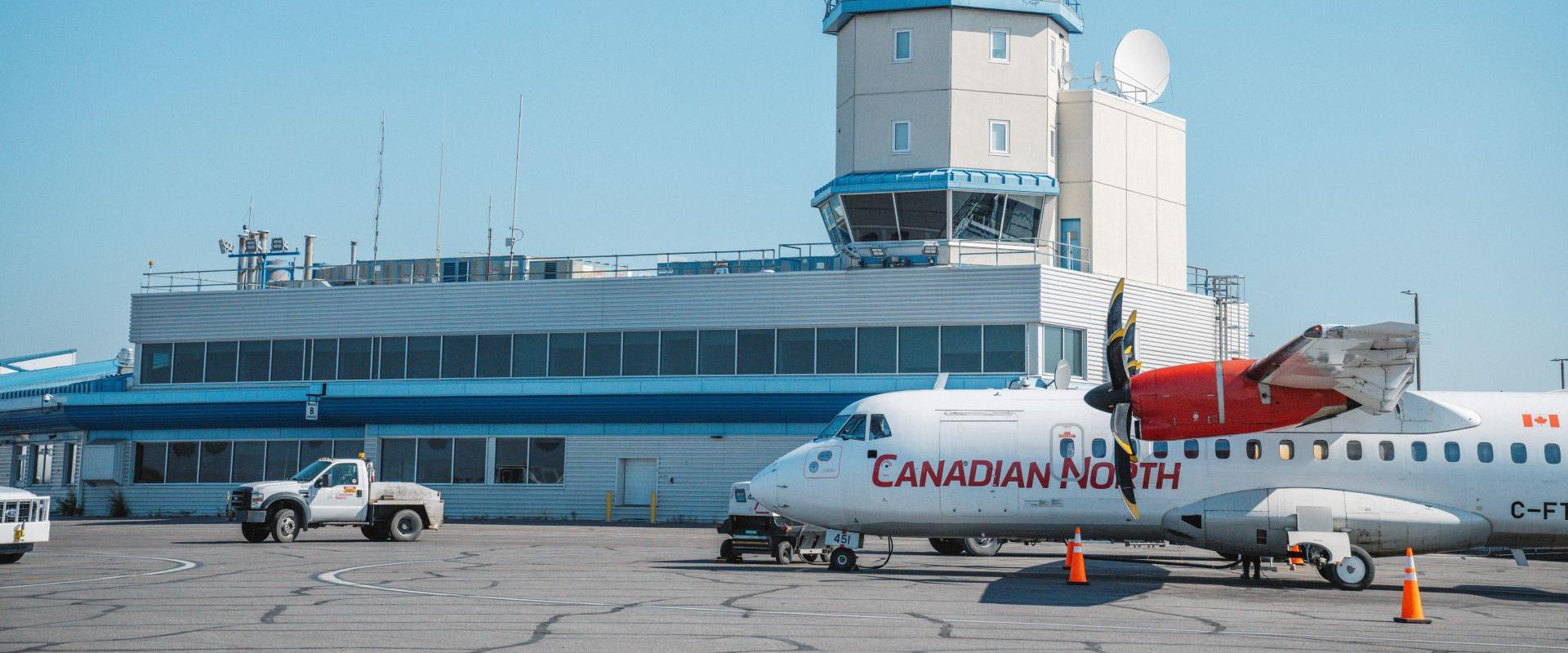 Image of aircraft parking in from of terminal building.